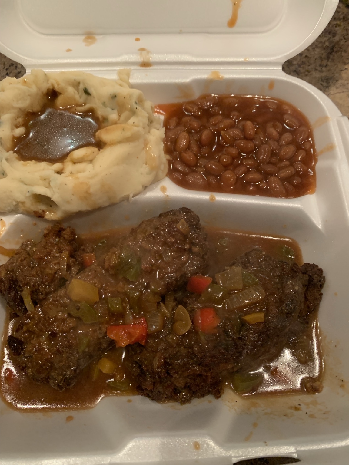 Vegan meatloaf with peppers and gravy, mashed potatoes and baked beans